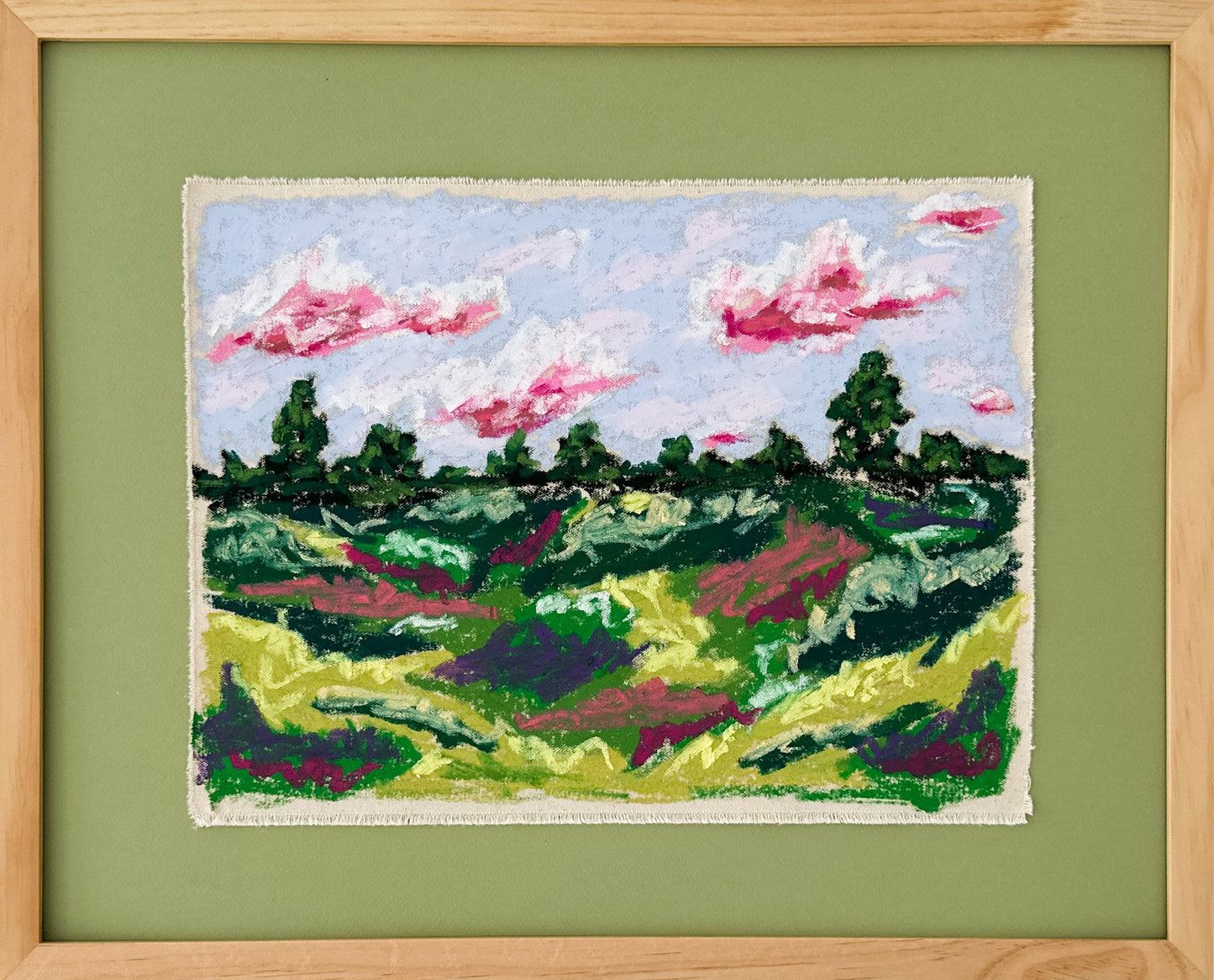 Framed textile art of a landscape with green fields and pink clouds on a green background