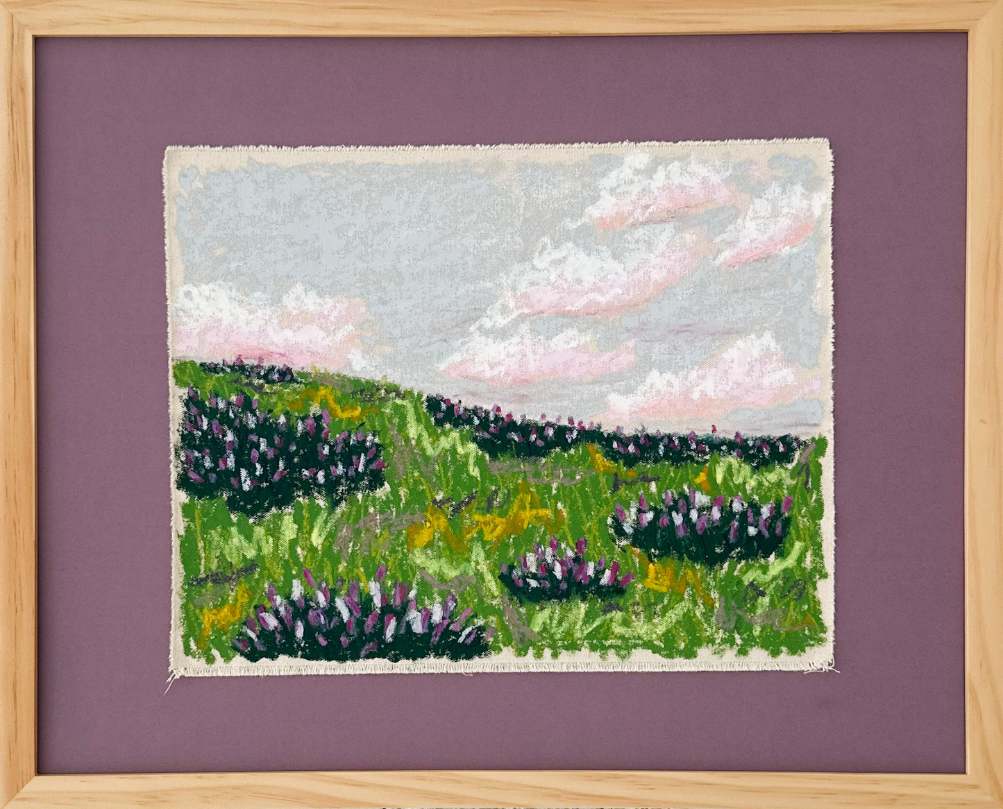 Framed  canvas  art of a landscape with green fields and purple flowers on a purple background